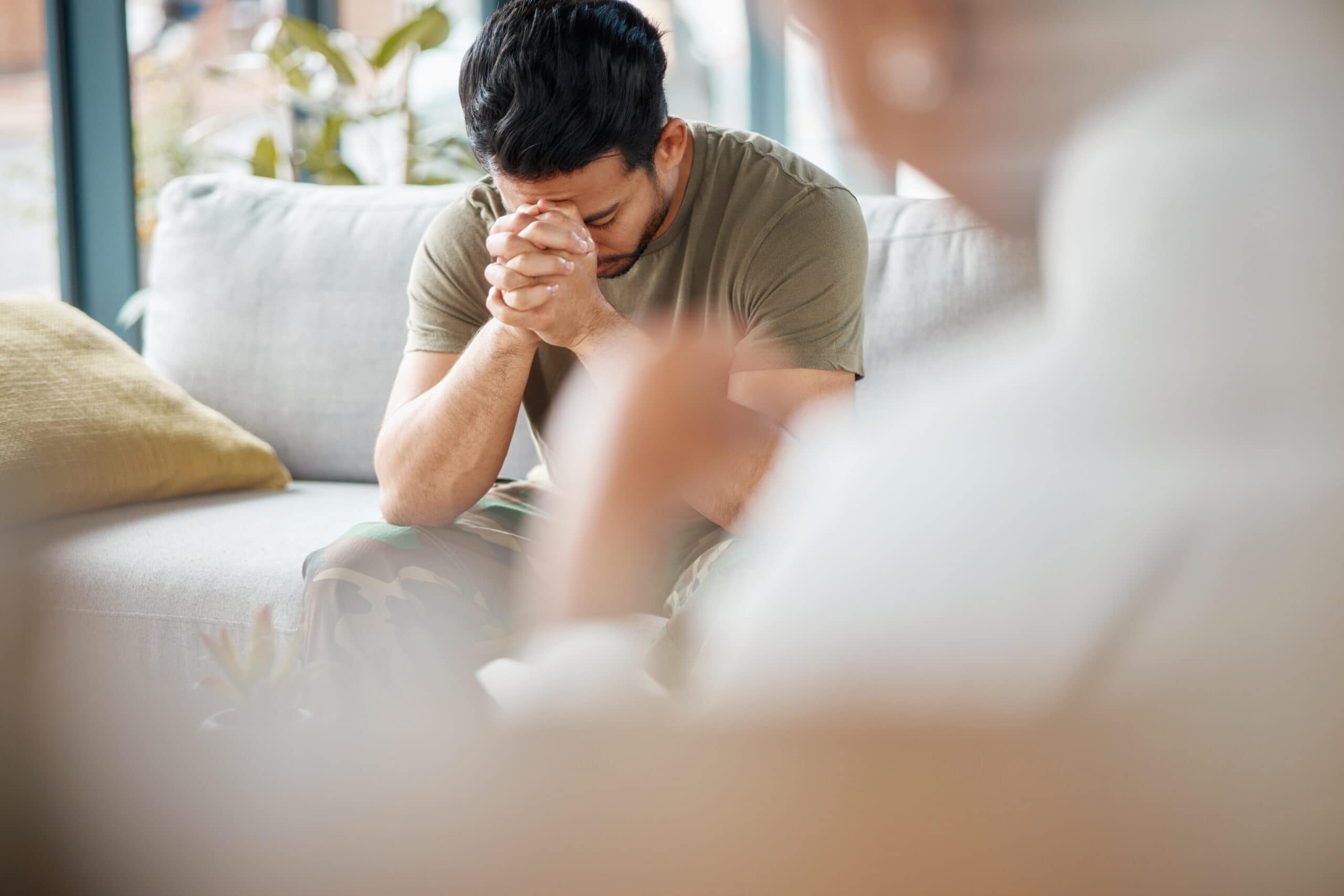 Sad, ptsd and male soldier in therapy for mental health, depression or grief after a military war. Frustrated, trauma and man army warrior talking to a psychologist about emotions in a clinic office